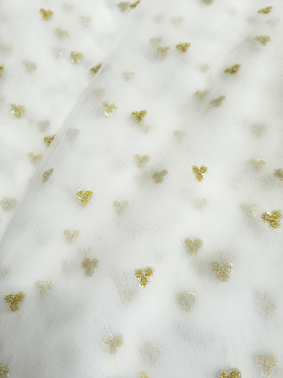 White fabric with small gold floral patterns

