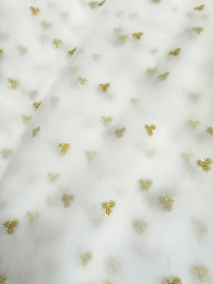 White fabric with small gold floral patterns

