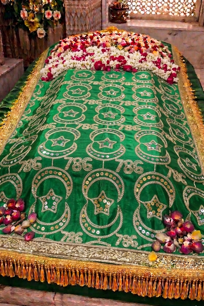 Decorative green cloth with gold patterns on a stone surface, surrounded by flowers.

