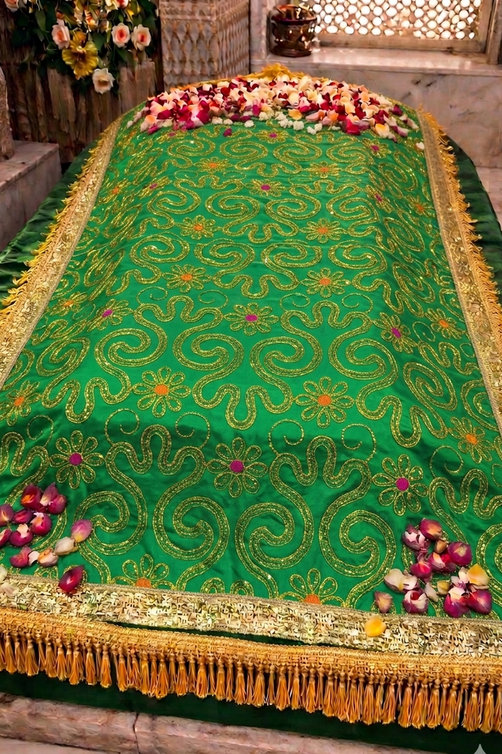 Decorative green cloth with gold patterns on a stone surface, surrounded by flowers.

