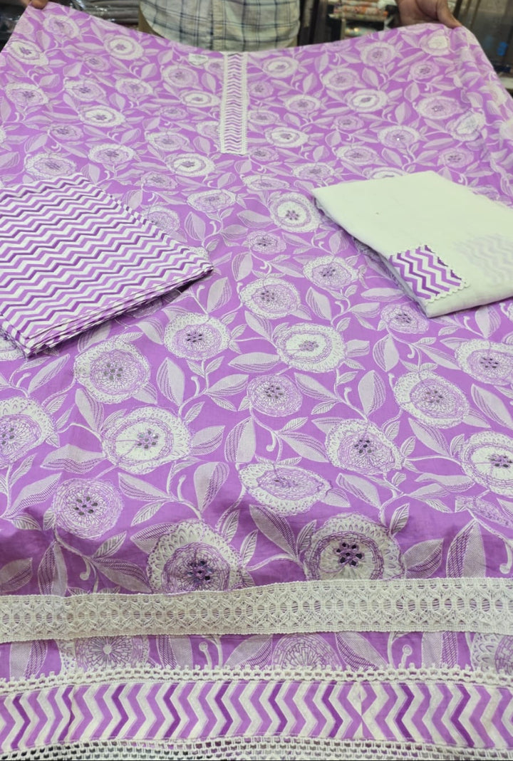 Purple fabric with white floral patterns displayed on a table.